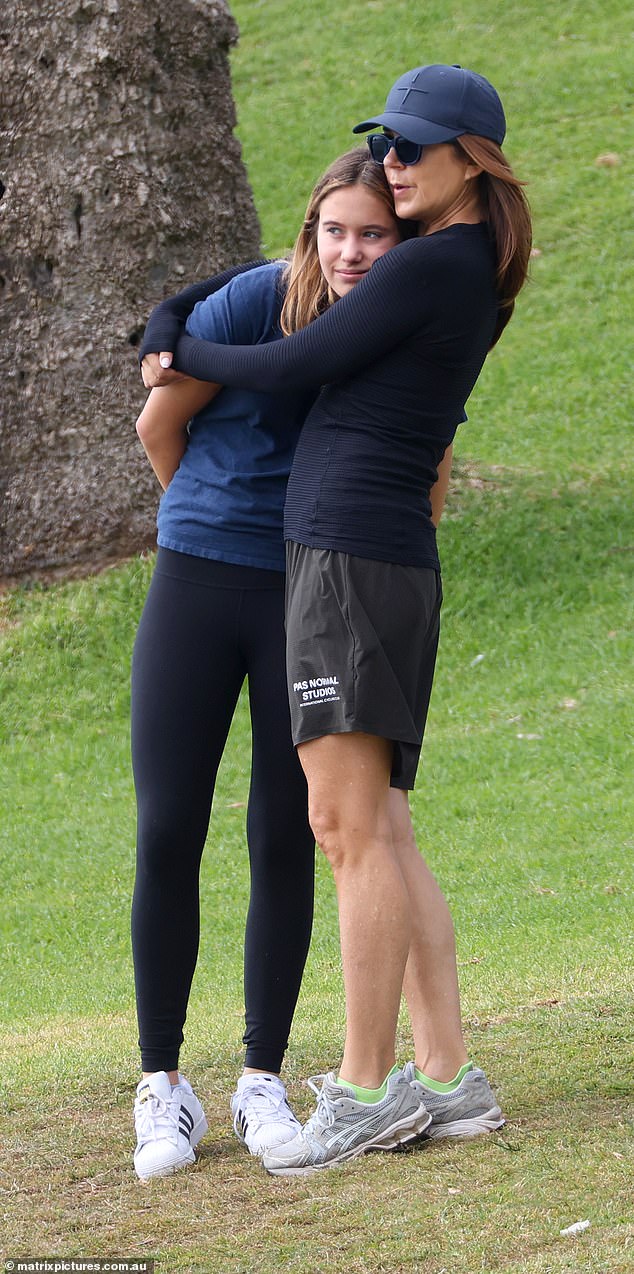 The queen cuddles with her daughter, who wore black tights and a blue T-shirt