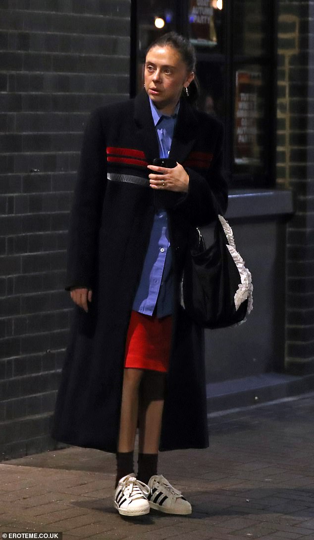 Dress for the crisp autumn air and wrap yourself in an ankle-length black trench coat with a red stripe across the chest