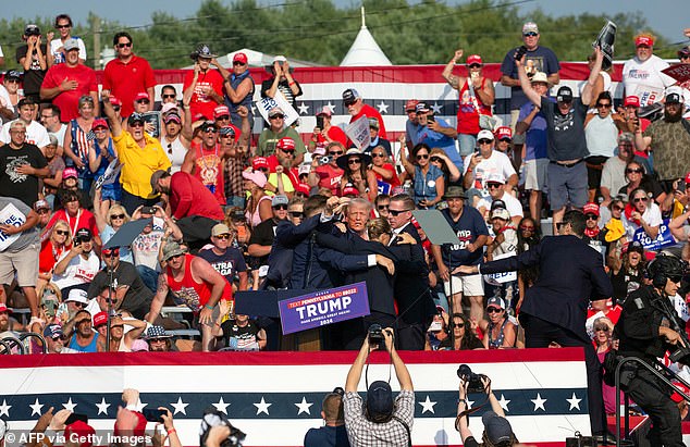 Republican candidate Donald Trump is seen with blood on his face surrounded by Secret Service agents as he is taken off stage during a campaign event in Butler, Pennsylvania, July 13