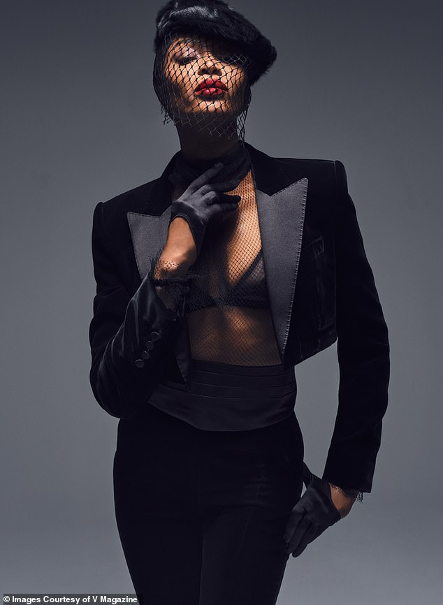 She added a black statement fascinator with a small veil and shot a smoldering look at the camera