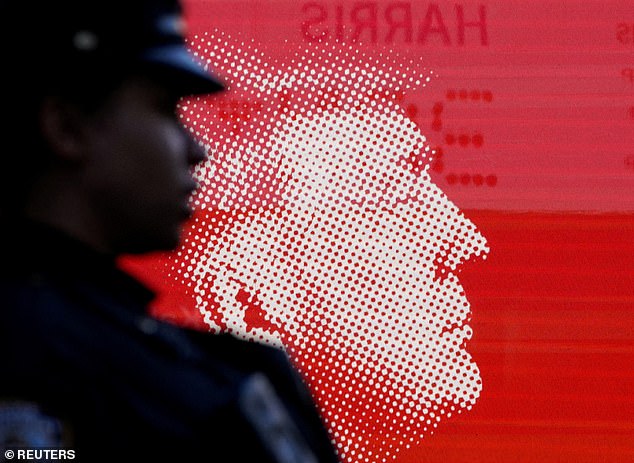 An NYPD officer stands in front of an image of Republican presidential candidate and former U.S. President Donald Trump outside Madison Square Garden on the day of Trump's rally