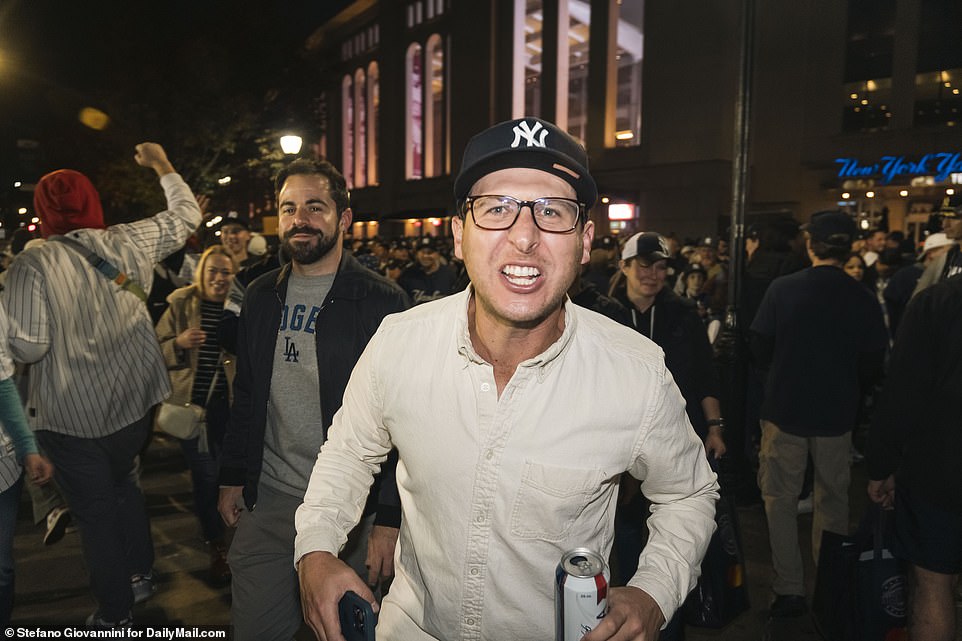 A fan drinking a beer screams with joy after watching his Yankees beat the Dodgers in the Bronx