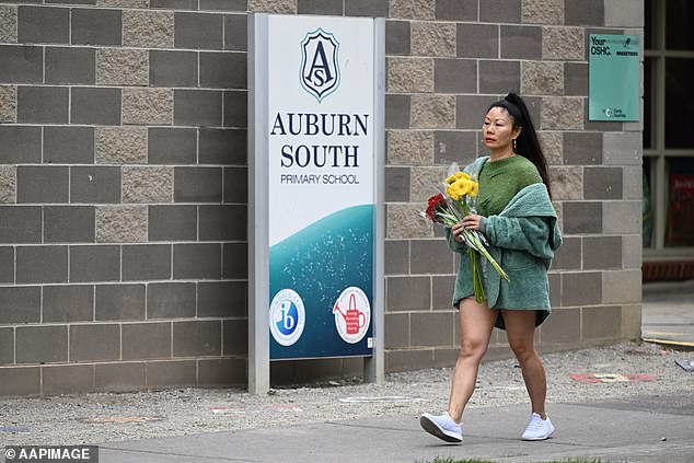 A woman is seen delivering flowers to Auburn South Primary School