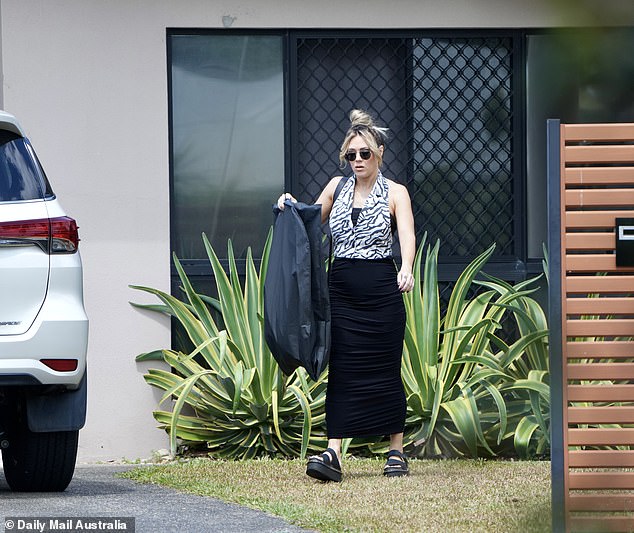 The photo shows the mother of four leaving the house on Wednesday morning with a dry cleaning bag