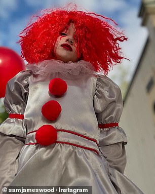 Sam pulled a comical Chucky mask over his head and wielded a fake knife, while three of their four kids were rocking their own spooky outfits for trick or treating.