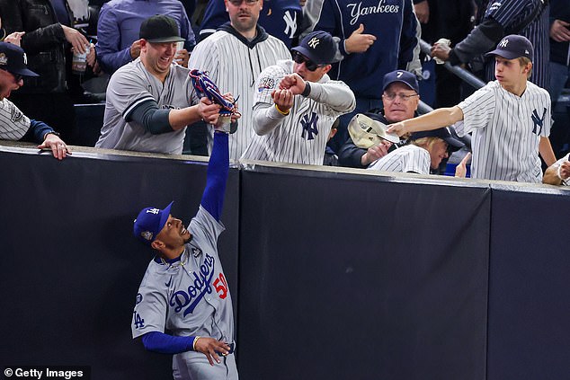 Both fans were ejected after the play, which took place in the first inning of Game 4