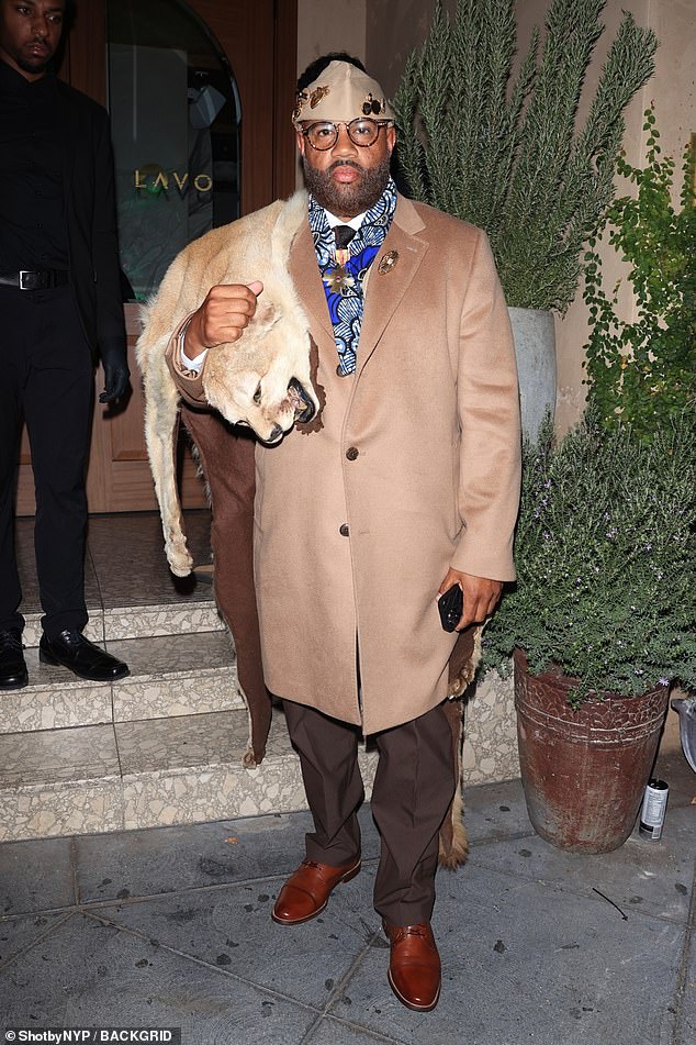 Co-host Lenny Santiago dressed as Eddie Murphy's comedy character Prince Akeem from his 1988 film Coming to America, complete with fake lion skin draped over one shoulder