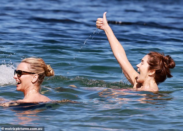 Mary laughed as she splashed and gave her friends a thumbs up