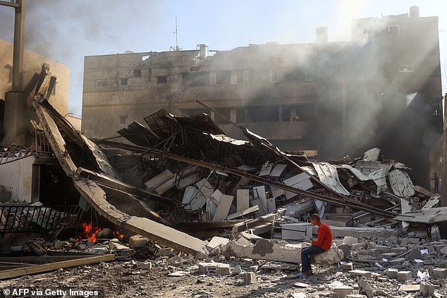 A Palestinian boy sits on the rubble of the destroyed Maghazi Camp Services Club building after an Israeli attack on the Maghazi refugee camp in the Gaza Strip on October 24, 2024