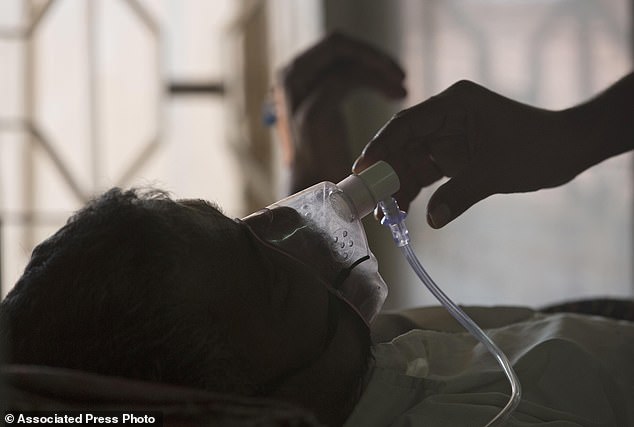 According to the World Health Organization, the number of cases of bacterial lung infection will rise to a record high of 8.2 million by 2023. Pictured earlier this year, a family member adjusting the oxygen mask of a tuberculosis patient at a TB hospital in Hyderabad, India