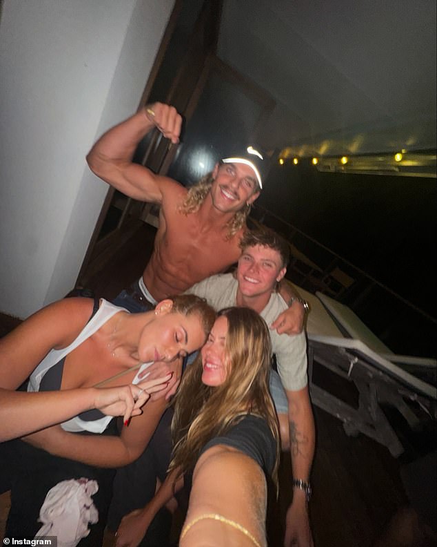 A third photo showed the ultra-fit star flexing his forearm muscles as he laughed with some attractive friends