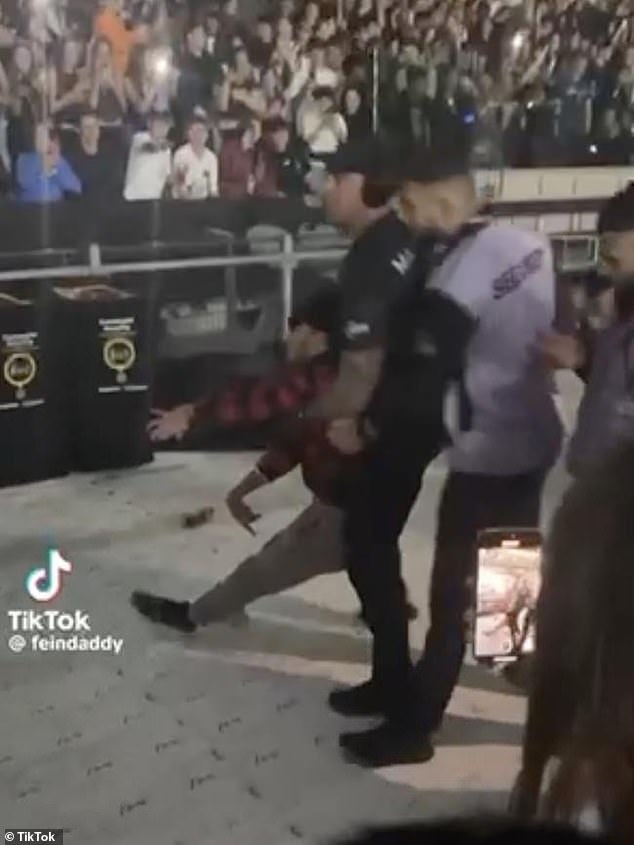 Footage of the incident was later shared to Tik Tok and shows a security guard holding the concertgoer under his arms as the man shakes uncontrollably. (Pictured)