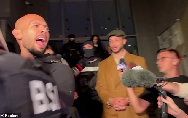 Footage from August shows Andrew Tate (left) insisting there is 'no evidence' against him as he was led into the back of a prison van by elite Romanian officers