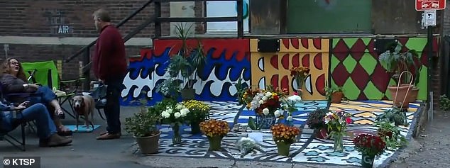 Pictured: the mural Kwok was working on when she was shot. Friends and loved ones have now placed flowers