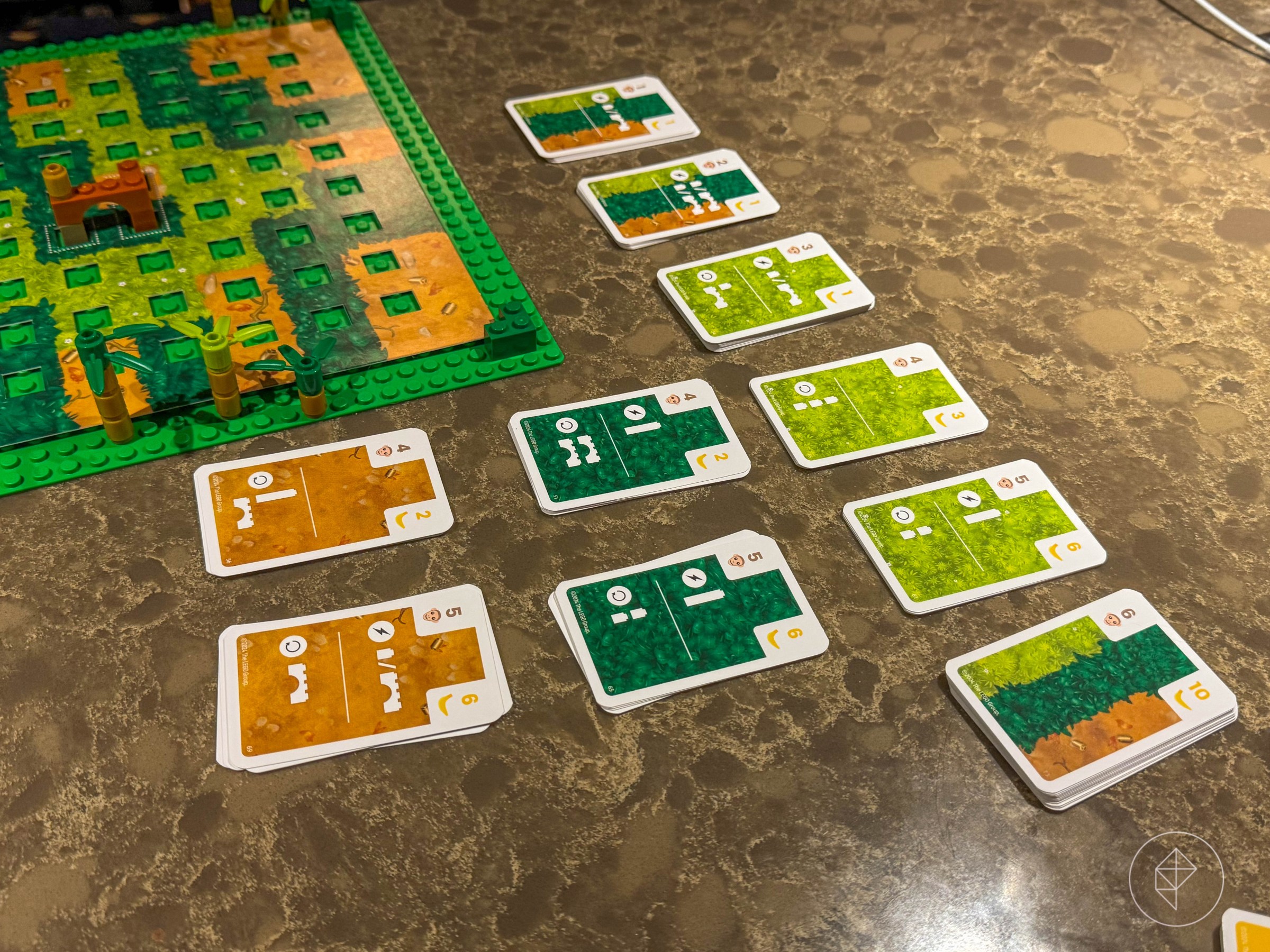 A series of green and brown cards with Lego pieces on them.