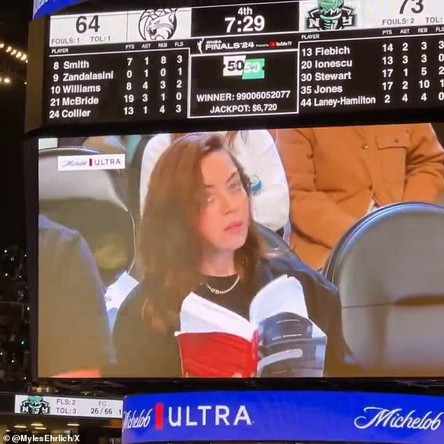 The Community star, 40, had courtside seats for the match and pretended to read a book as the action took place just inches away from her.