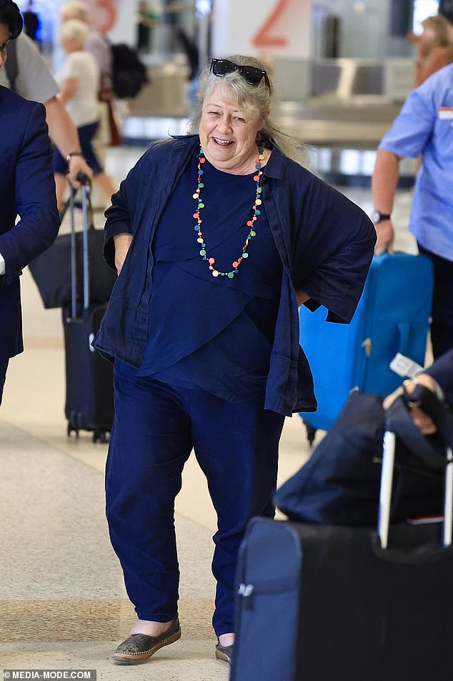 She completed her look with a pair of comfortable gray shoes and wore a colorful necklace