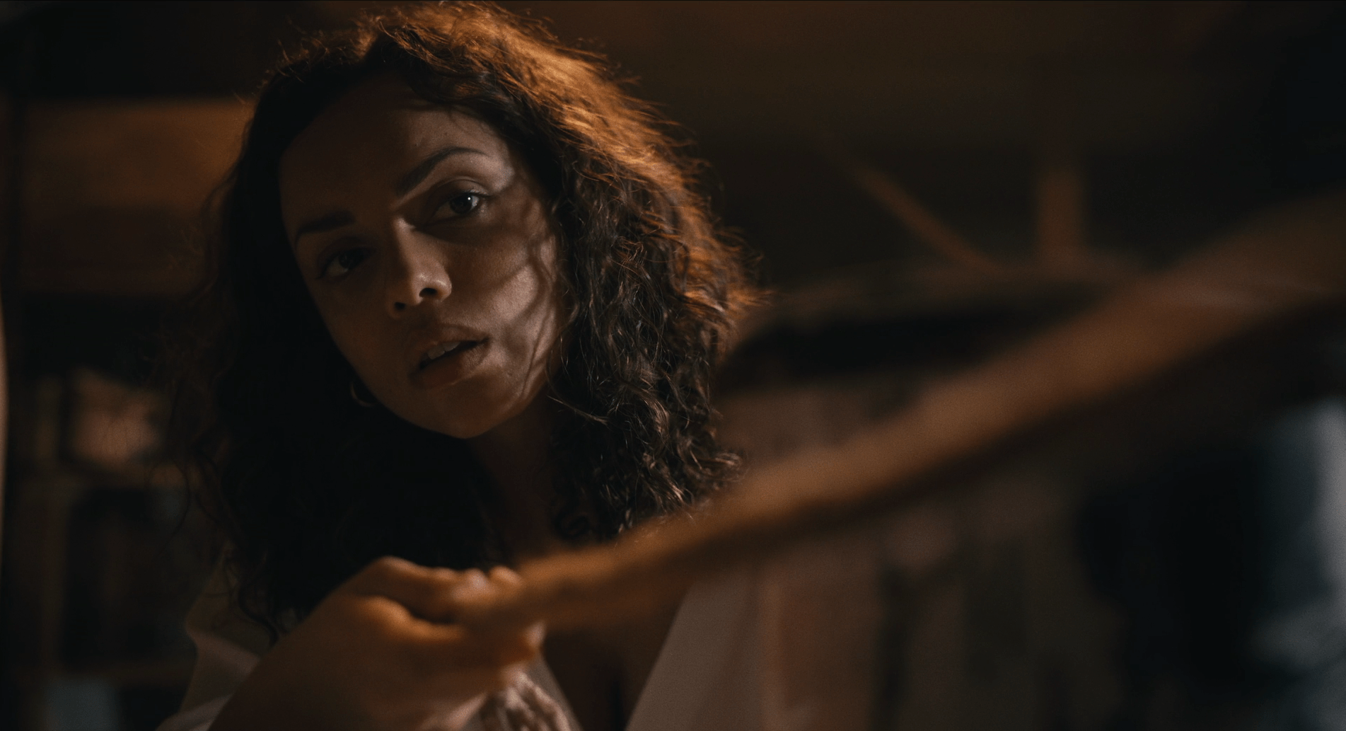 Georgina Campbell looks curious as she pulls a rope in a dark, small room in Barbarian