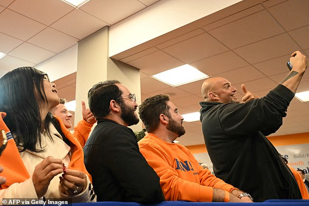 Pennsylvania Senator John Fetterman (right) takes a selfie with LiUNA union workers Saturday during an event in downtown Pittsburgh with President Joe Biden in support of Vice President Kamala Harris