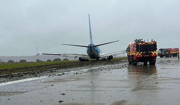 A Boeing aircraft suffered a 'catastrophic failure' and skidded off the runway in a crash at Leeds Airport during Storm Babet in October 2023. Pictured: Dramatic photos show the TUI aircraft lying on the side of the runway at Leeds Bradford Airport