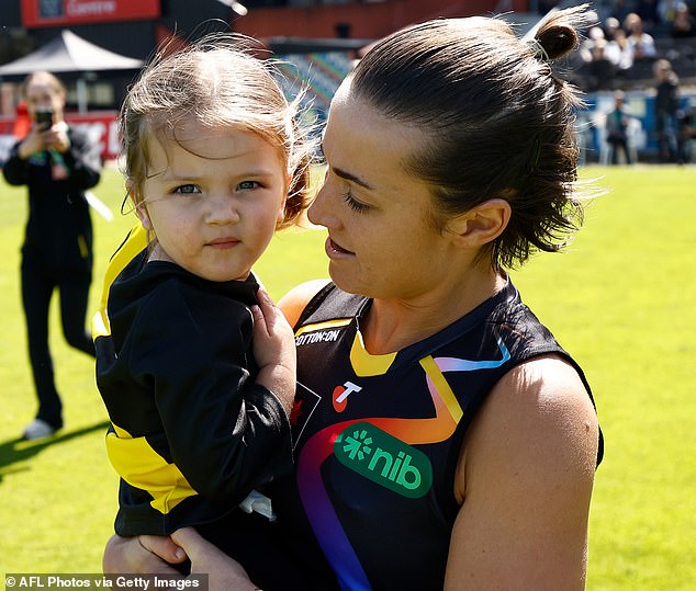 Kate Dempsey (pictured with daughter Pippa) faced homophobic abuse on social media after writing about her footy journey