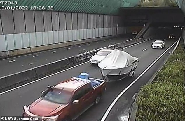 Stein is depicted driving out of the Lane Cove tunnel with the barrel in the back covered by a blue tarpaulin