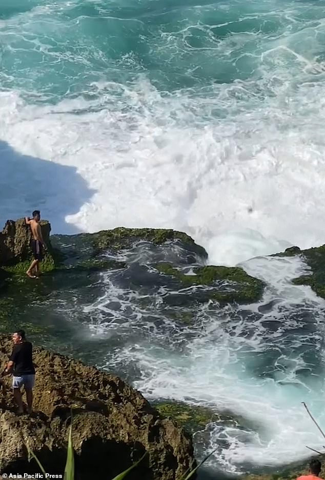 Rony Josua Simanjuntak, 21, from North Sumatra, stood on wet rocks before being washed away by the large wave. Pictured above left