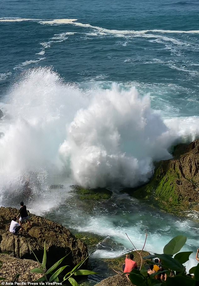 Horror footage captured the moment the tourist was washed away by the huge wave as he posed for photos at the seaside spot