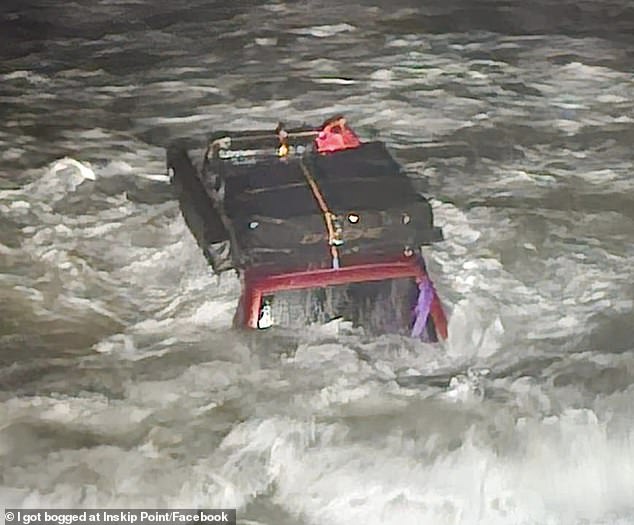 One of the 4WDs hit by waves and almost completely submerged as French tourists attempted to cross Queensland's infamous Mudlo Rocks (pictured)