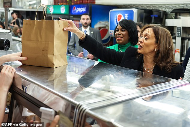 Vice President and Democratic presidential candidate Kamala Harris grabs food during a stop at the Famous 4th Street Delicatessen while campaigning in Philadelphia, Pennsylvania.