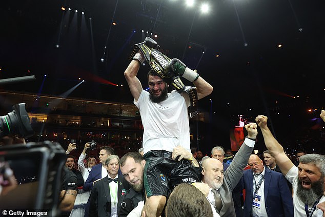 Beterbiev pictured Saturday night holding the undisputed light heavyweight belt