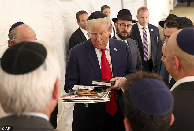 Republican presidential candidate, former President Donald Trump, talks with members of the Chabad Lubavitch after visiting the grave of Rabbi Menachem Mendel Schneerson, Monday, October 7, 2024, in New York