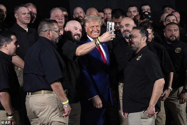 Republican presidential candidate, former President Donald Trump, talks to members of the U.S. Border Patrol before speaking during a campaign rally, Sunday, Oct. 13, 2024, in Prescott Valley, Arizona