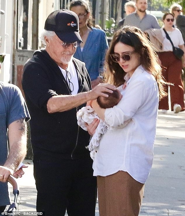 The disgraced 87-year-old actor - who faced a slew of sexual assault allegations in 2017 - beamed as he placed a hand on the three-week-old child's head.