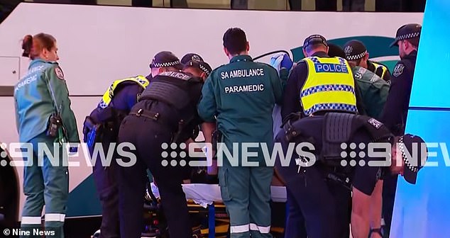 A number of police officers were injured following the incident in Adelaide on Saturday (paramedics and police pictured on scene at the Franklin Street terminal)