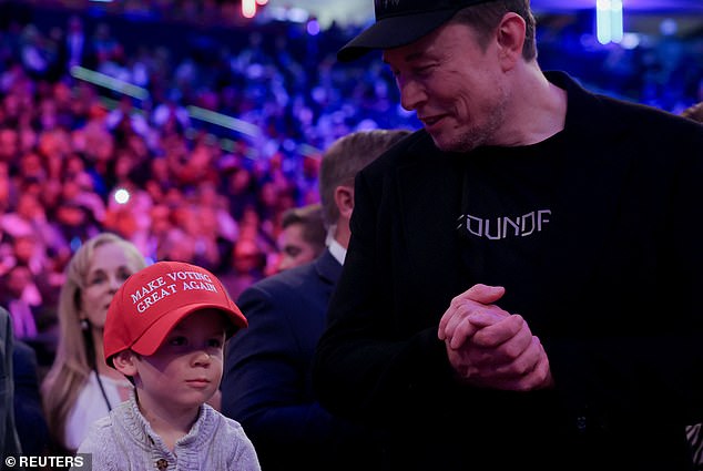 During Donald Trump's Sunday rally at Madison Square Garden in New York City, Elon Musk smiles at his son who is wearing an oversized, custom MAGA hat that reads: 'Make Voting Great Again'