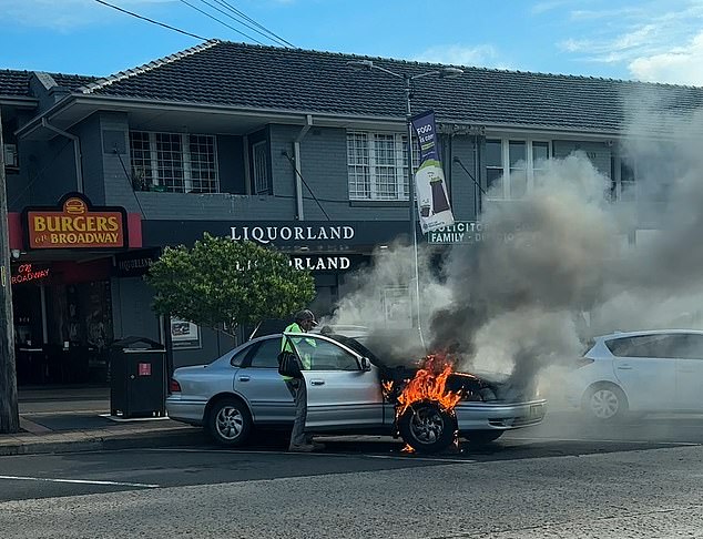 He then starts going about his business as if nothing was out of the ordinary and despite the cries of a nearby bystander for him to 'go away'. He even opens the driver's door and appears to be searching for something completely unaffected by the fire.