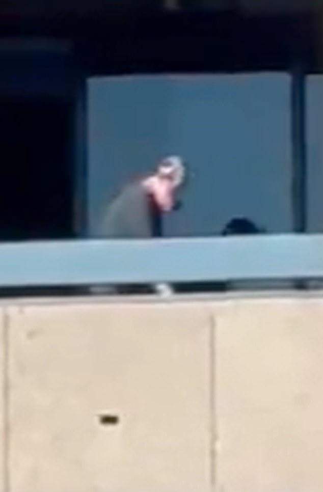 The unidentified gunman, wearing a light-colored rubber mask, fired a round of rapid fire at people filming him from another balcony just as the clip ended.