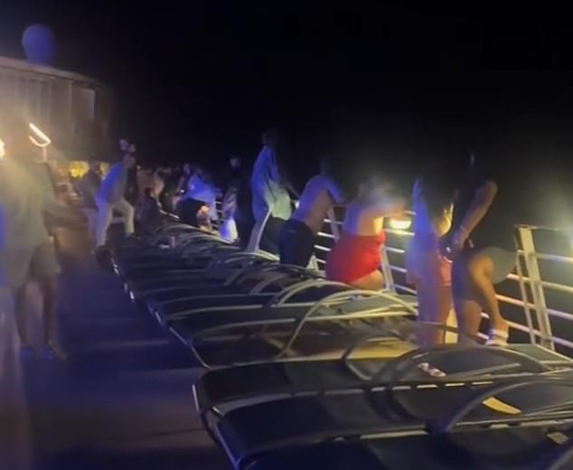 A frantic search ensued after a woman fell overboard while vacationing on a Taylor Swift-themed Royal Caribbean cruise in the Bahamas. Pictured: Passengers queue after the unidentified woman fell overboard on Tuesday