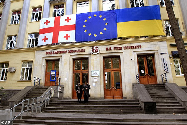 From left: Georgian national, EU and Ukrainian national flags hang at a polling station during the parliamentary elections in Tbilisi, Georgia, Saturday, October 26, 2024