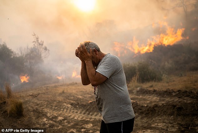 Last year was officially the hottest year since global records began in 1850. Pictured, a man recoils as a fire burns in the village of Gennadi on the Greek island of Rhodes in the Aegean Sea, July 25, 2023