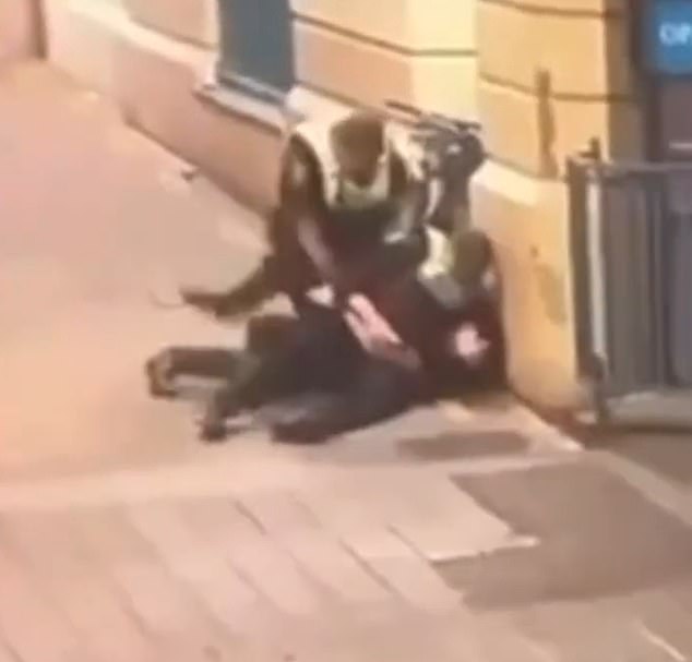 Two officers tried to control a man who threw his phone at one of them and followed up with punches