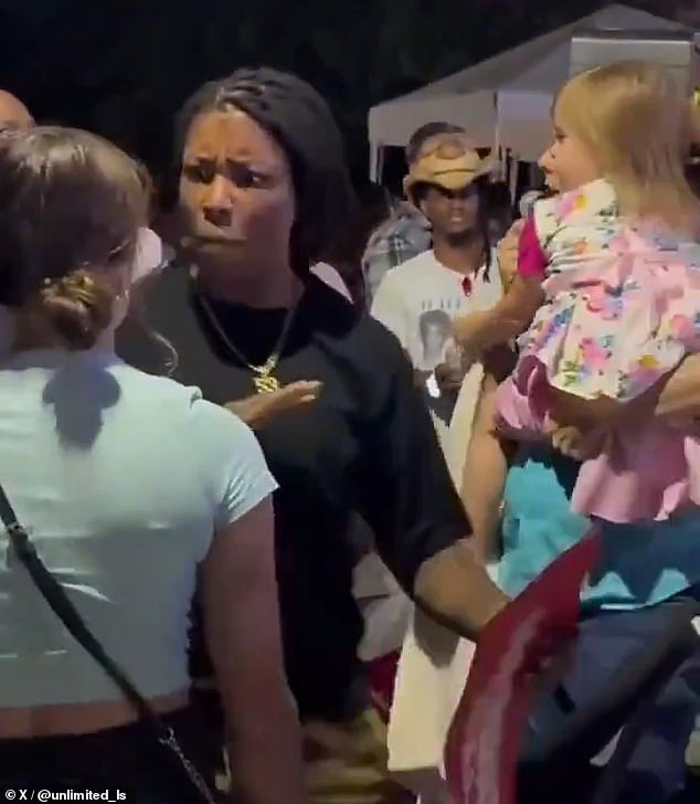 The young woman was pulled away by another supporter nearby, while the child's father picked her up and spoke back into his microphone.