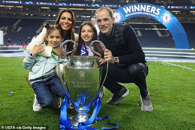 The family poses next to the 2021 Champions League trophy in Porto