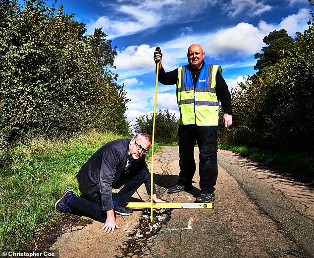 Mark Morrell, aka Mr Pothole, measures a deep hole in the road with Mail's Toby Walne