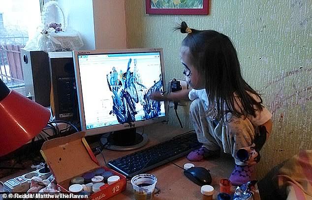 Self-expression: A little girl found no better support for her painting work than her parents' computer monitor, and climbed onto the table for better access