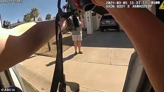 The photo shows U.S. Marshals arriving at Penny McCarthy's Phoenix home with guns drawn. They tell her to raise her hands, shout orders at her and threaten her with violence several times