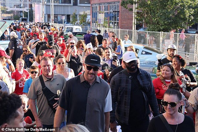 A crowd of fans follows Travis Kelce after he arrived at his charity event on Saturday night