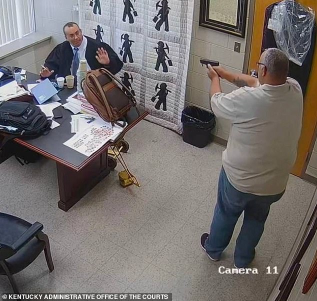 A shocking new photo has emerged showing a Kentucky sheriff pointing a gun at a judge moments before he was shot dead