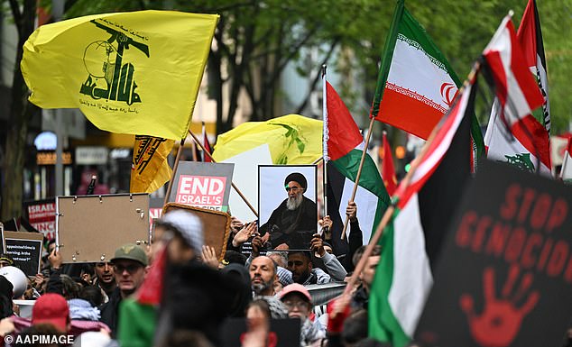 Protesters in Melbourne were seen holding up framed photos of recently murdered Hezbollah boss Hassan Nasrallah (pictured centre) and Hezbollah's yellow and green flags (pictured left).